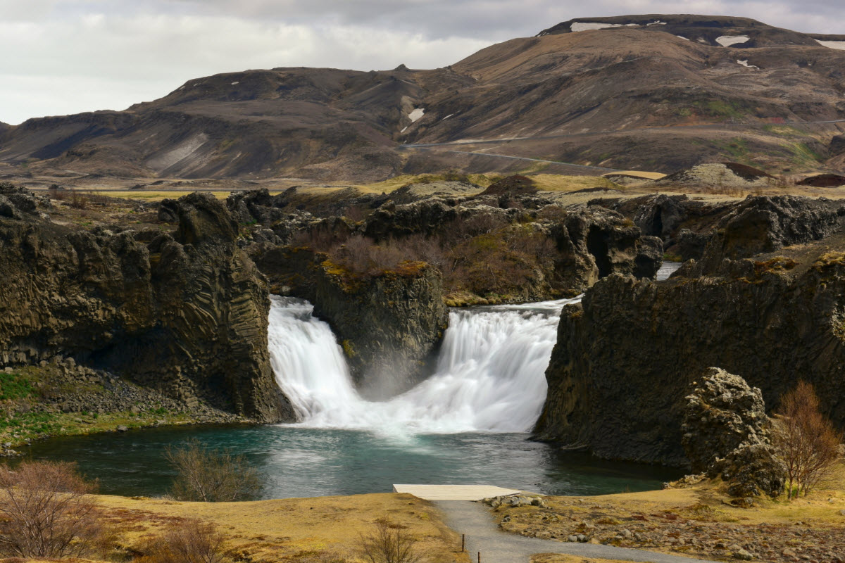 Hjalparfoss waterfall is located in a lava field north of the volcano Hekla