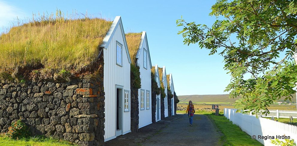 Woman walking next to turf houses