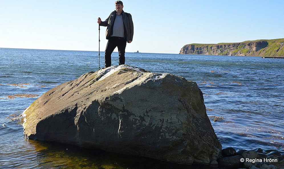 Man on the top of a big rock on the beach