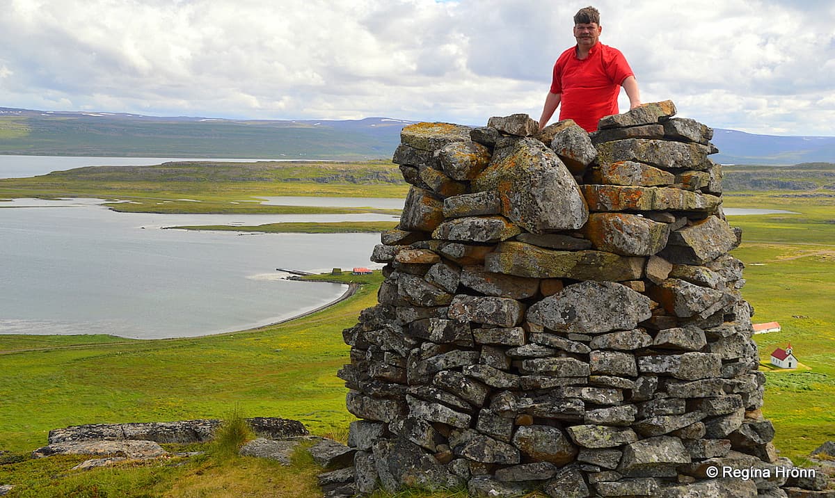 Man standing inside a cairn, ocean view